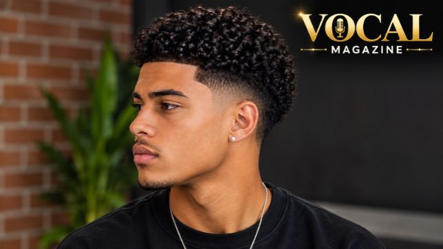 Low Taper Fade Curly Hair with natural textured curls and a clean, low fade around the sideburns and neckline