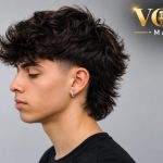 Low taper mullet haircut with faded sides, textured top, and longer hair at the back
